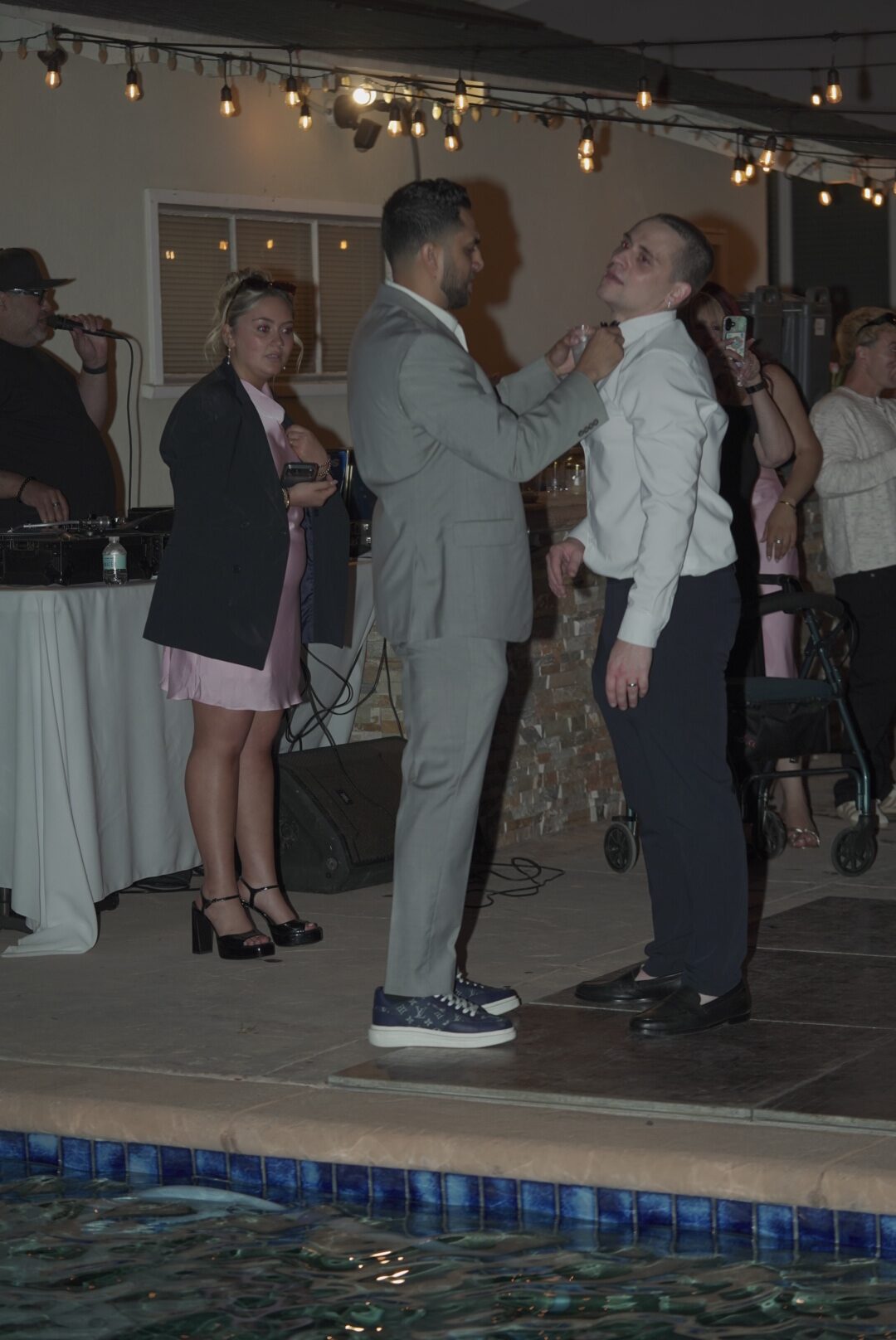 Guests sharing a candid moment beside a pool during an event.
