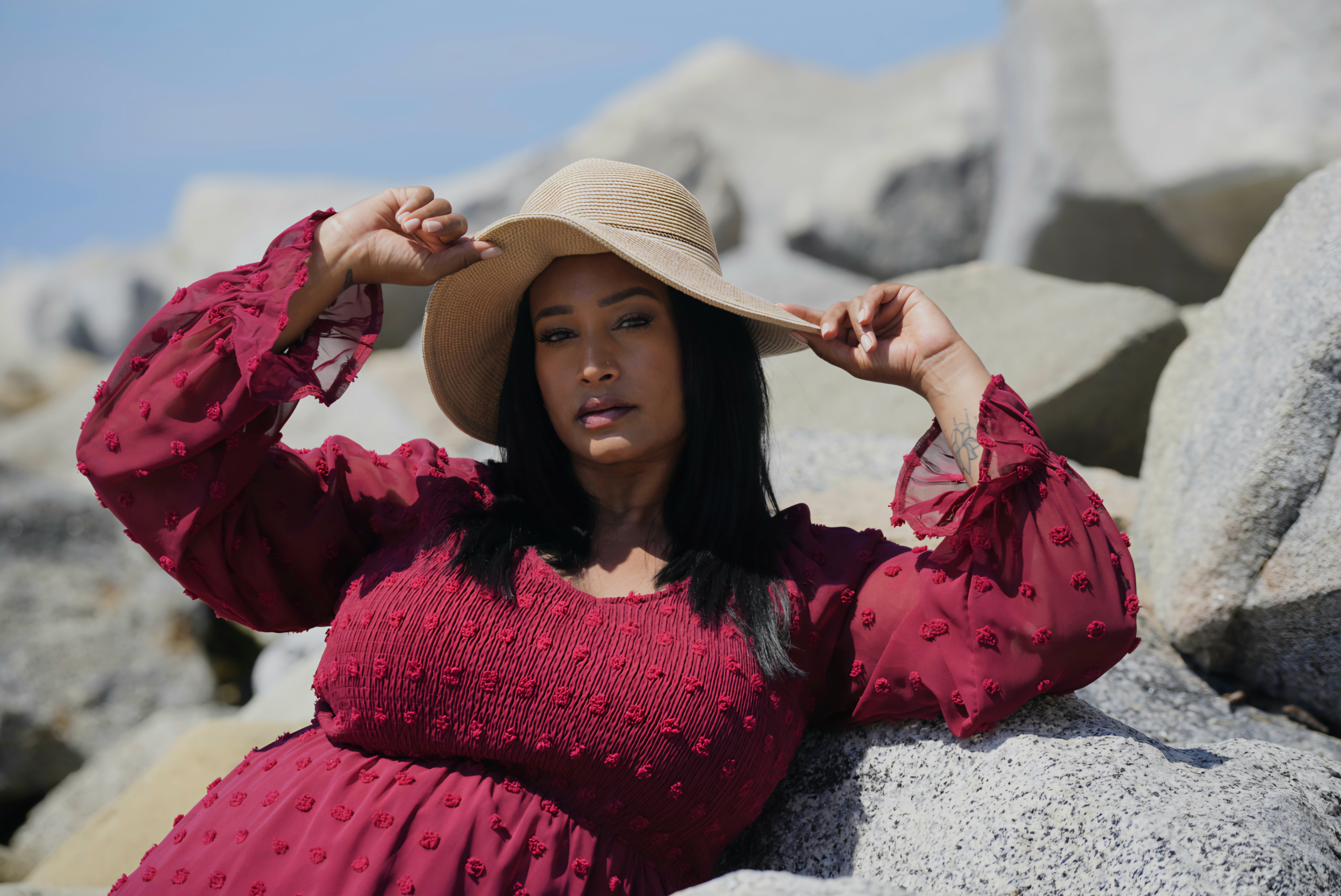 Beach portrait in a red dress on coastal rocks